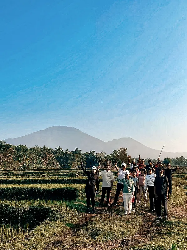 A group of guests in the rice terraces with the mountains behind
